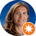 Smiling woman with wavy hair against a blue circular background, with an orange star icon in the corner.