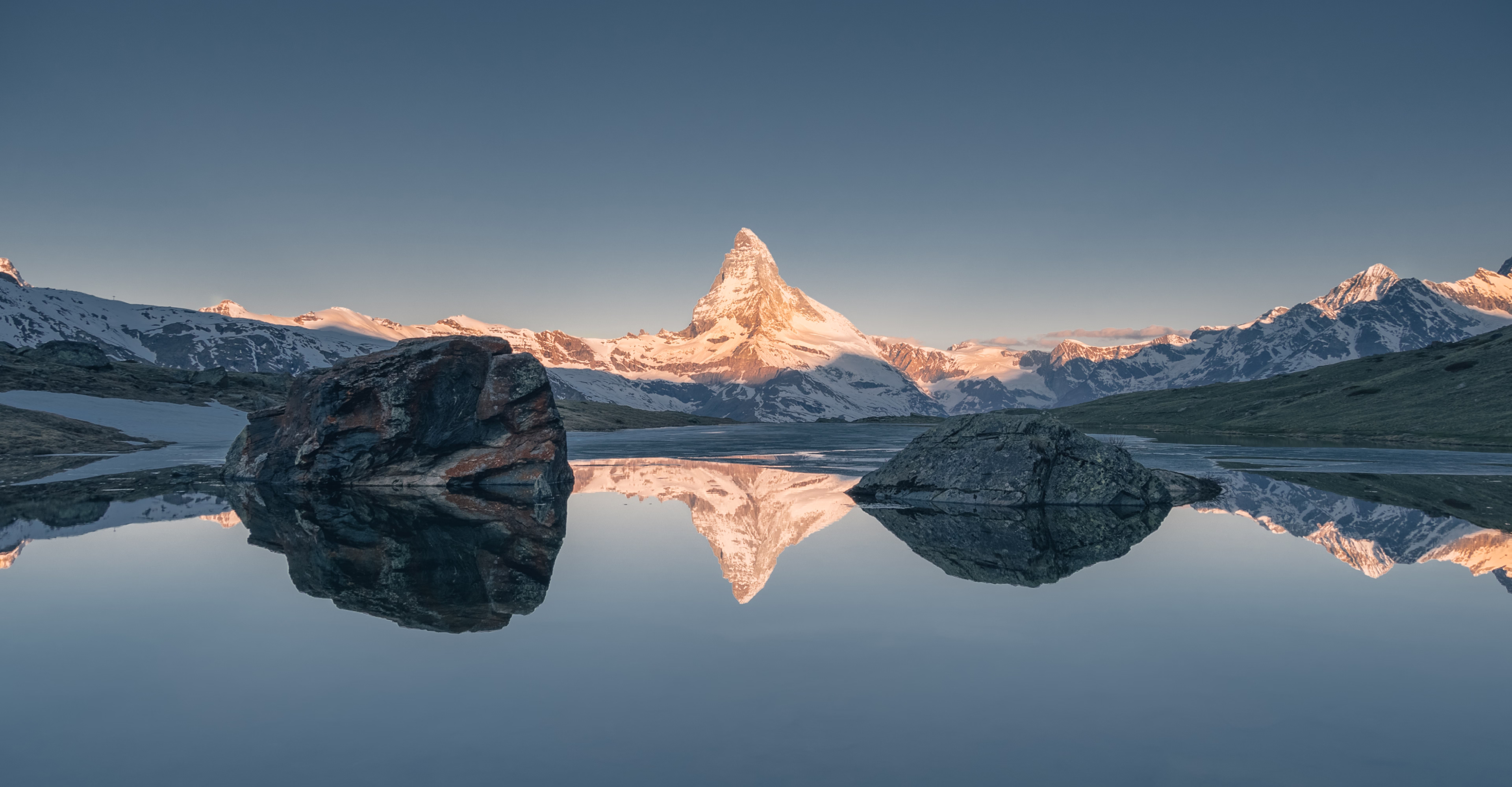 Mountain peak reflected in an alpine lake at sunrise