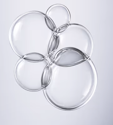 Cluster of six transparent soap bubbles overlapping on a light gray background.