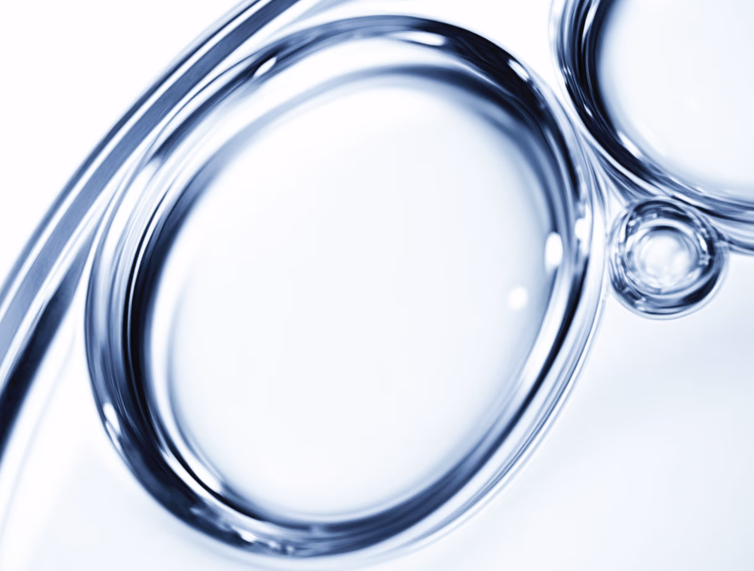 Close-up of transparent liquid bubbles with smooth edges in a light background.
