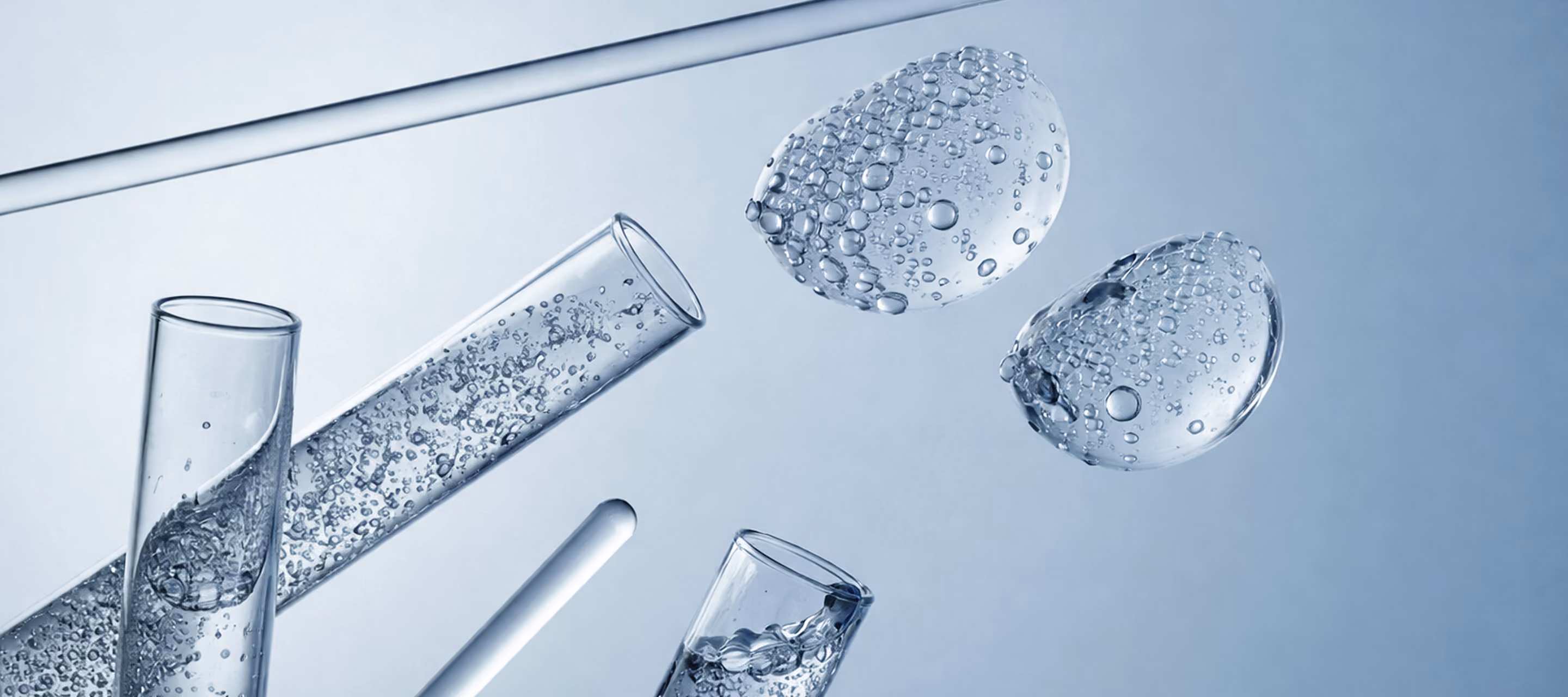 Clear glass laboratory tubes with bubbles floating in blue liquid solution.