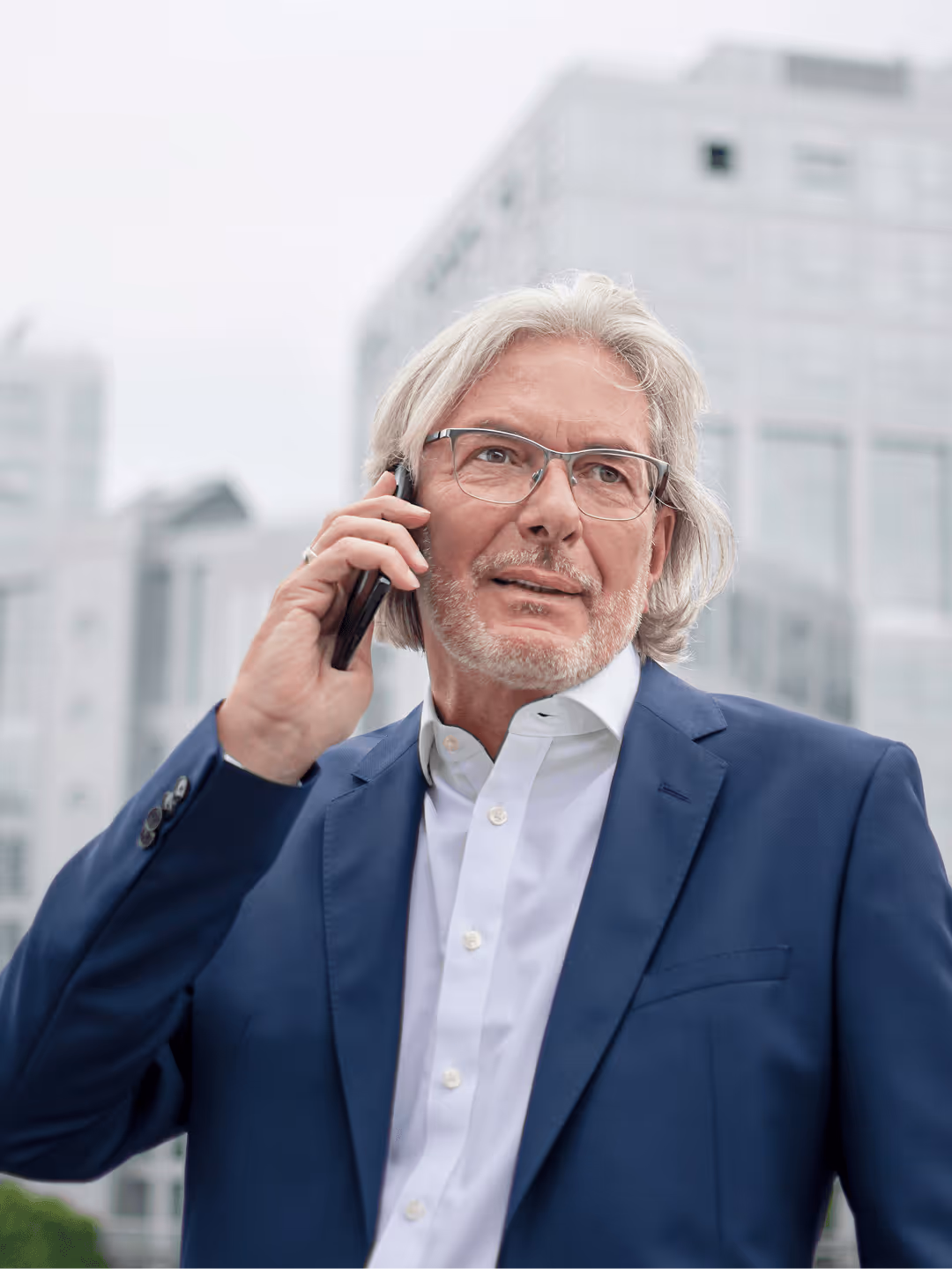 Ein telefonierender Mann vor einem Gebäude