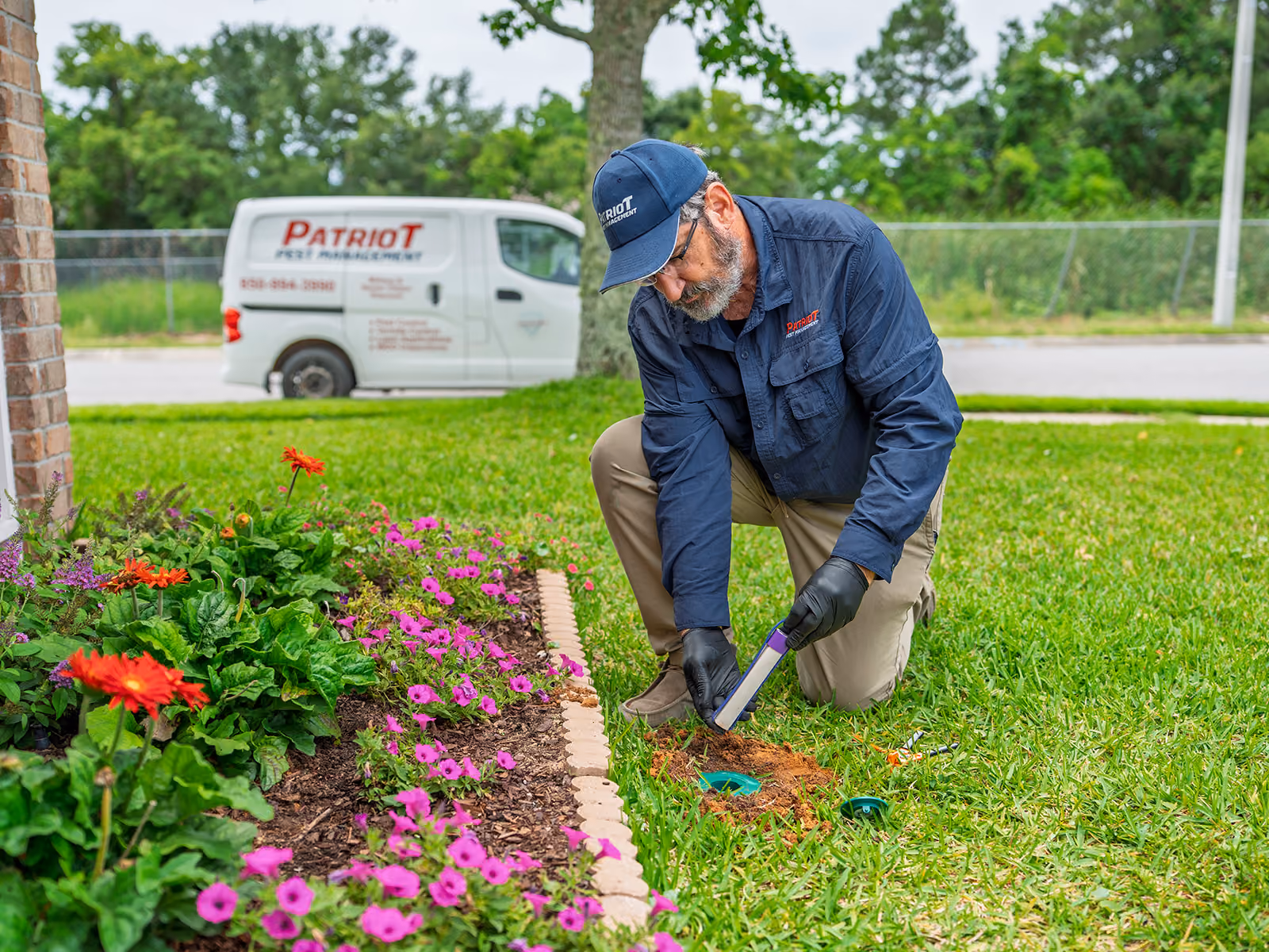 florida termite control technician checking a bait station