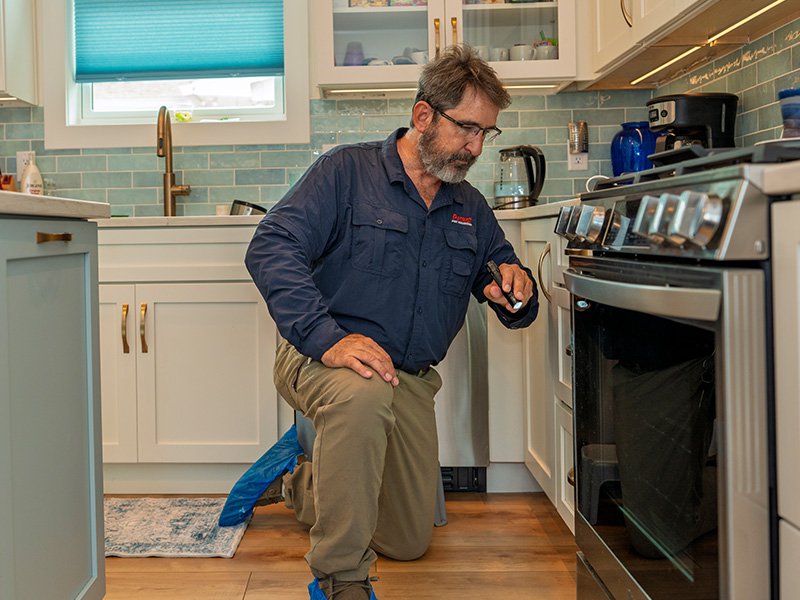 pest tech inspecting oven