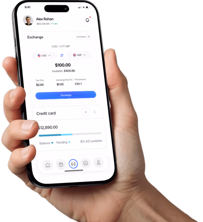 Hand holding smartphone displaying currency exchange app showing $100 USD to GBP conversion.