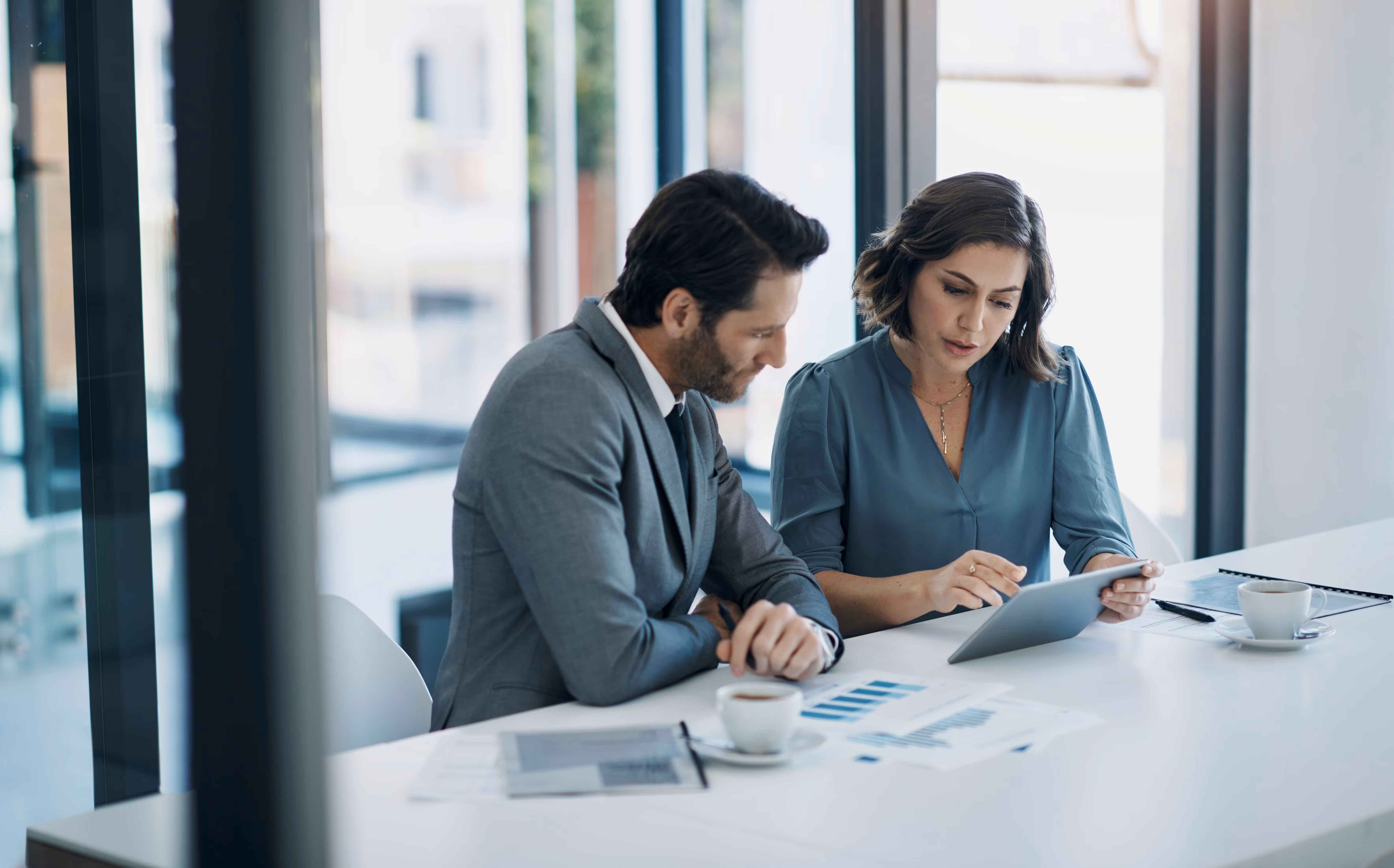 Deux dirigeants consultant une tablette en réunion – Neovoxia Executive Search
