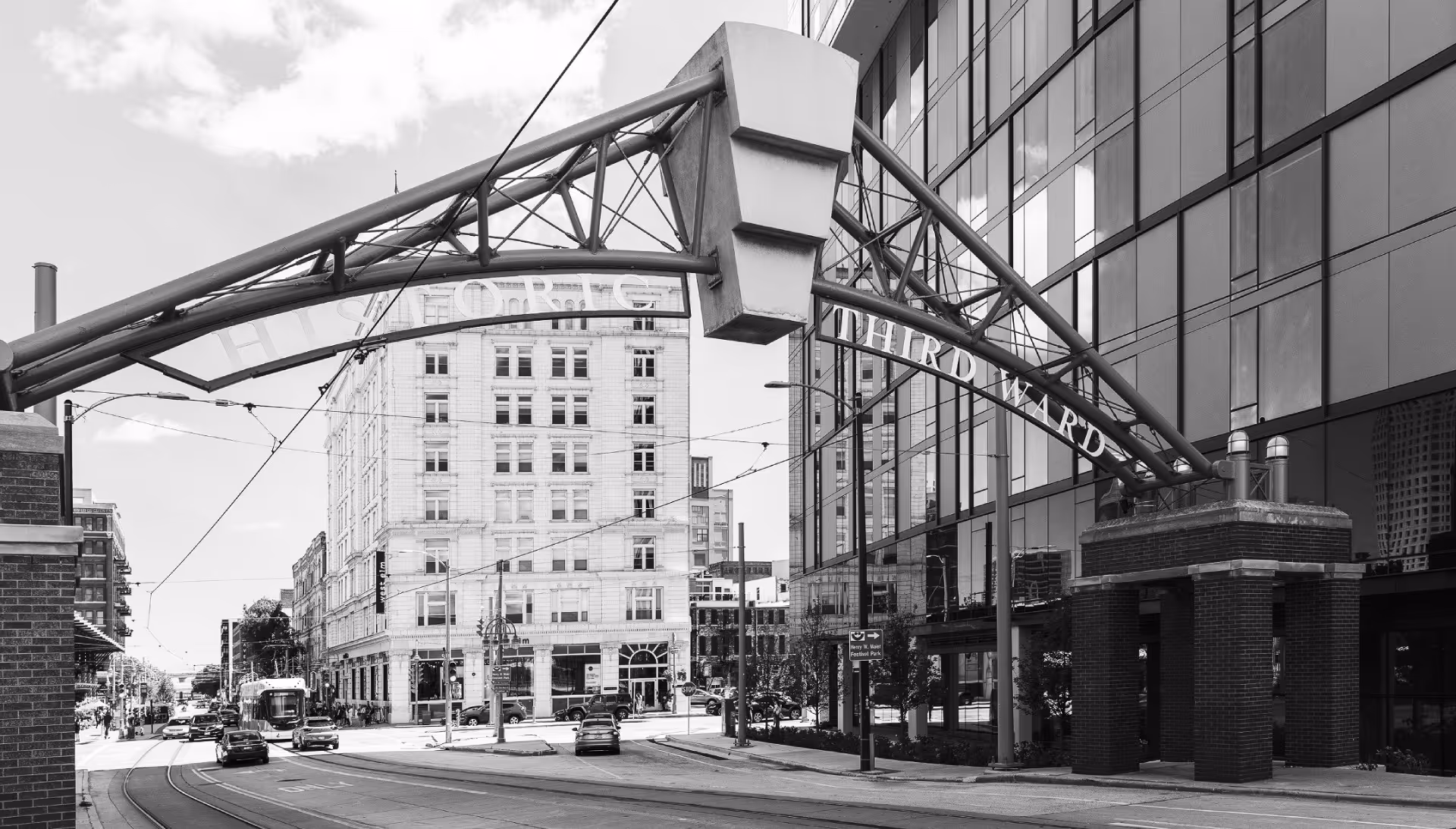 Historic Third Ward arch over an urban street with buildings and traffic.