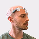 Mann mit Elektroenzephalographiekappen und Elektroden, der die Augen schließt.