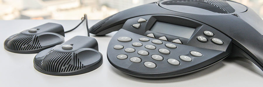 Polycom conference phone with external microphones on desk for business VoIP communication