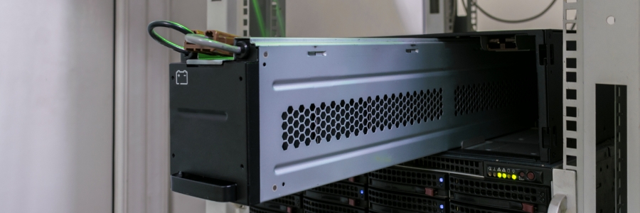 Rack-mounted UPS unit with ventilation panel installed in a server rack alongside network equipment