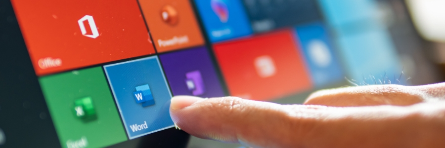 Finger tapping Microsoft Word tile on touchscreen displaying Microsoft 365 Office app icons
