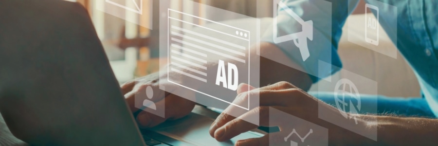 Person typing on laptop with overlaid digital ad icons representing online marketing analytics and IT business strategy
