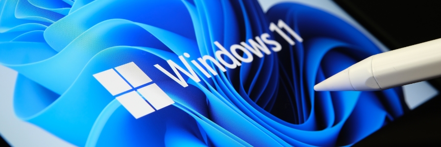 Windows 11 logo and branding displayed on a tablet screen with a stylus pen touching the display