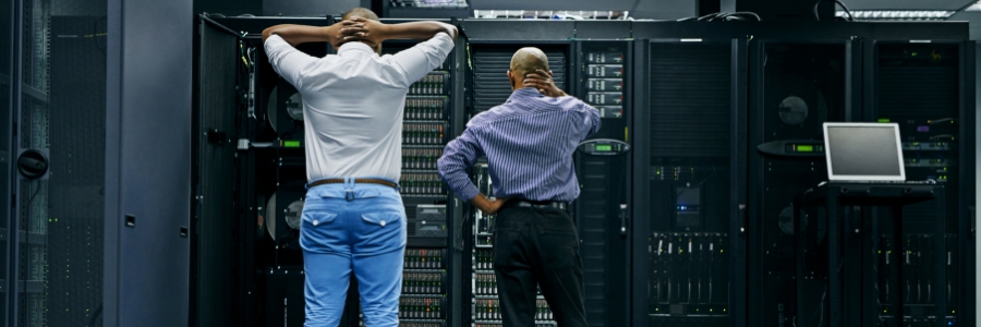 Two IT technicians troubleshooting server rack errors in a data center network room