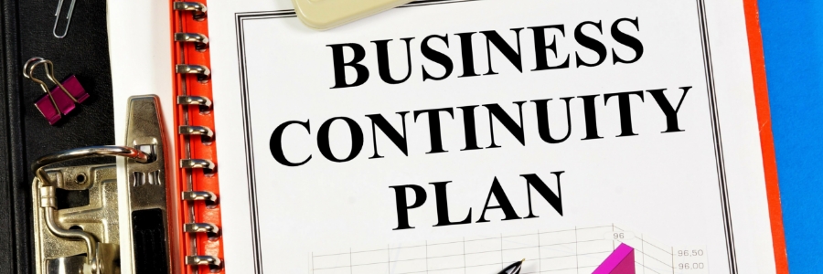 Business continuity plan document on clipboard with office supplies, representing SMB IT disaster recovery planning