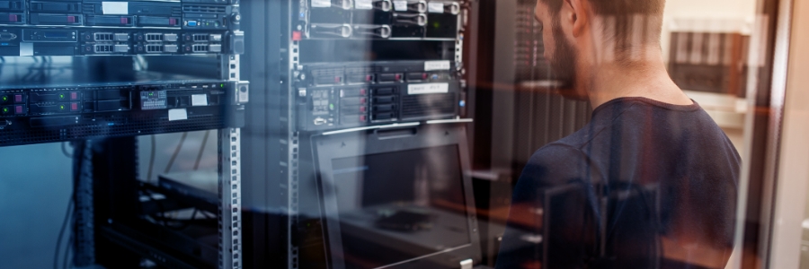 IT technician inspecting server rack equipment in a data center during infrastructure evaluation