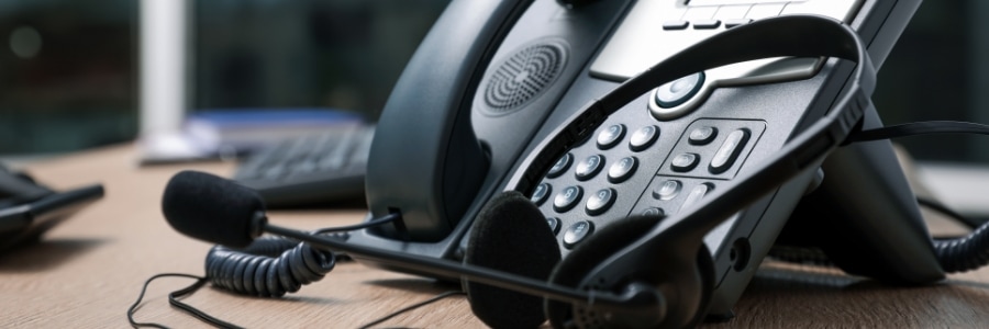 VoIP desk phone and headset on office desk, representing business communication technology solutions