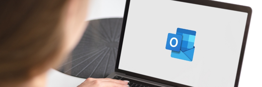 Person using laptop displaying Microsoft Outlook logo, illustrating email productivity tools for business IT users