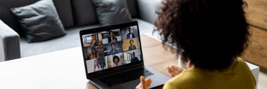 Person participating in video conferencing call on laptop, joining remote team meeting from home office