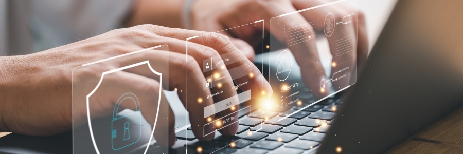 Hands typing on a laptop with glowing digital login screens and a cybersecurity shield icon overlay