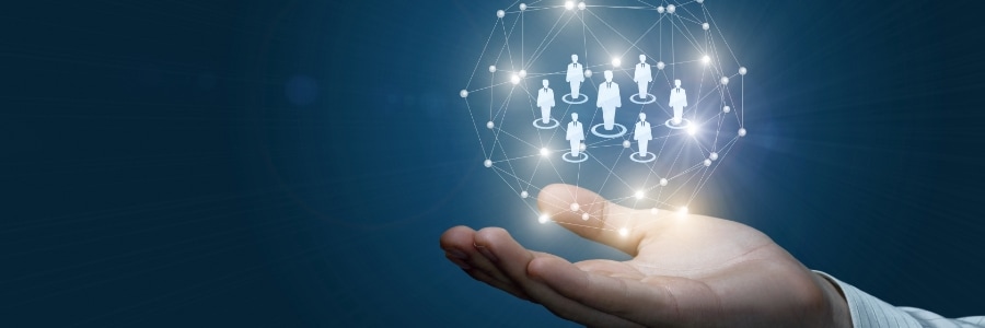 Hand holding glowing digital network of connected business people icons representing managed IT team collaboration