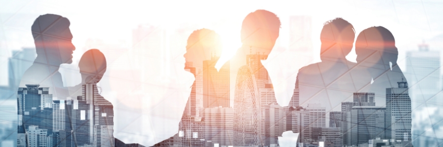 Silhouettes of business professionals in conversation overlaid on a city skyline double exposure