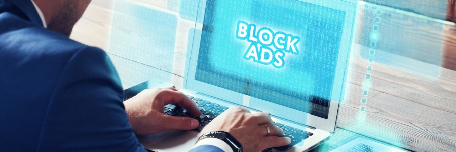 Business professional typing on laptop displaying glowing "Block Ads" text overlay with digital binary code interface