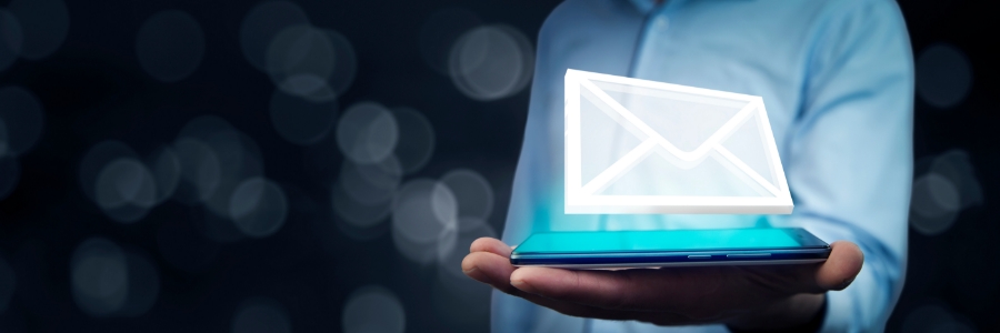 Person holding a smartphone with a glowing email envelope icon floating above it in a dark background