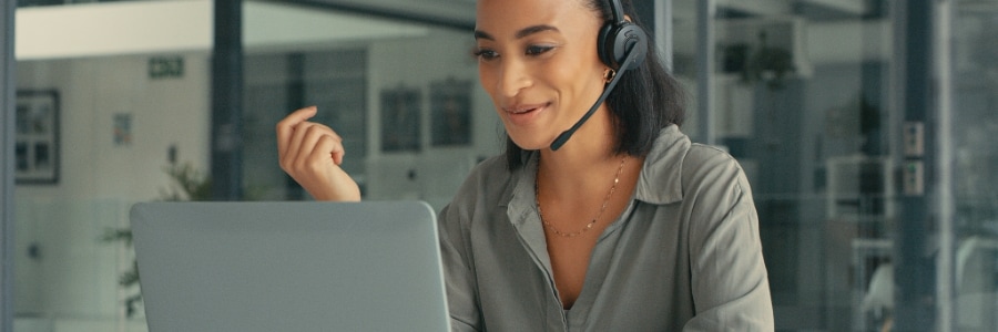 Business professional using headset and laptop for VoIP communication in modern office