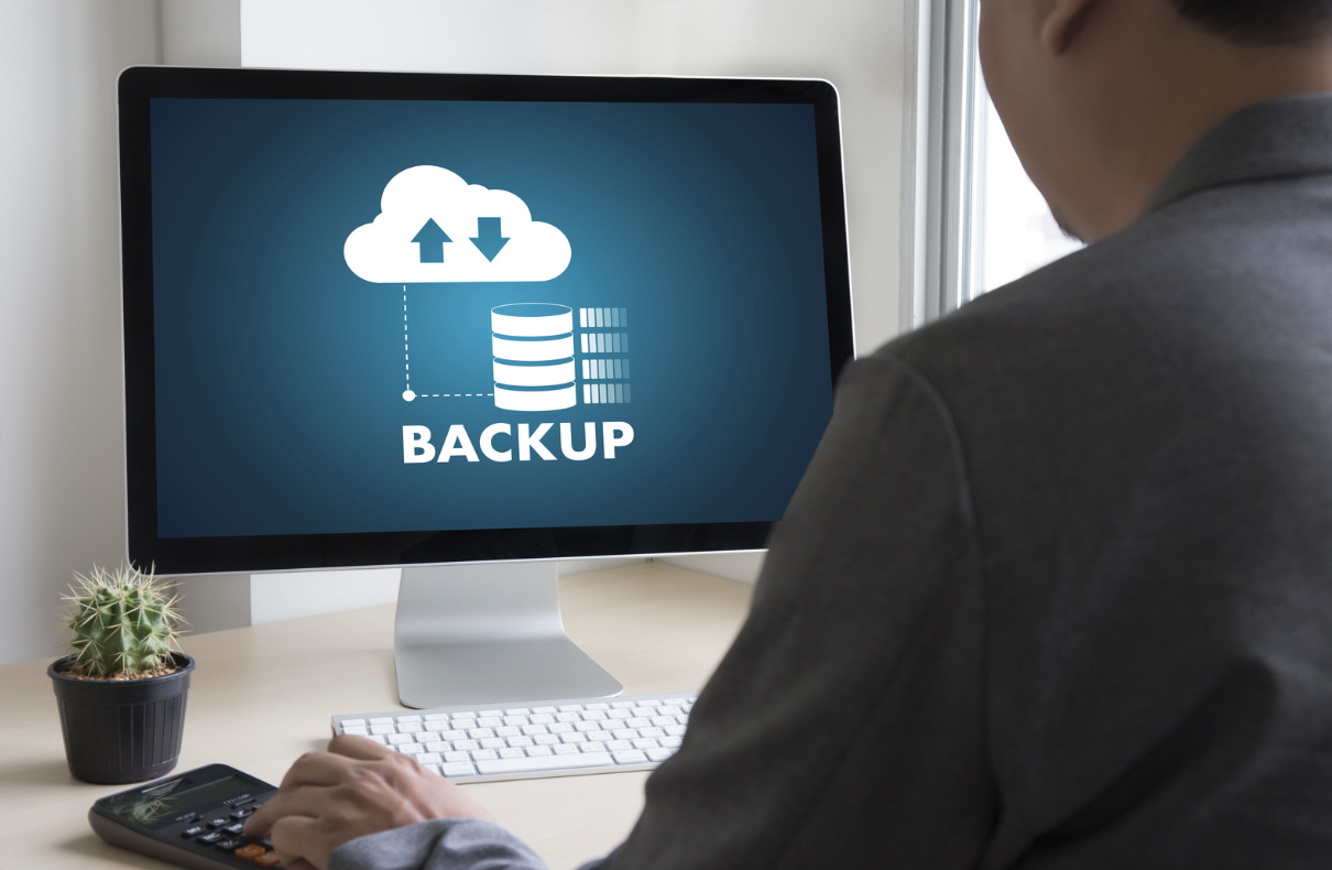 IT professional managing cloud backup and data storage solutions on desktop computer in modern office