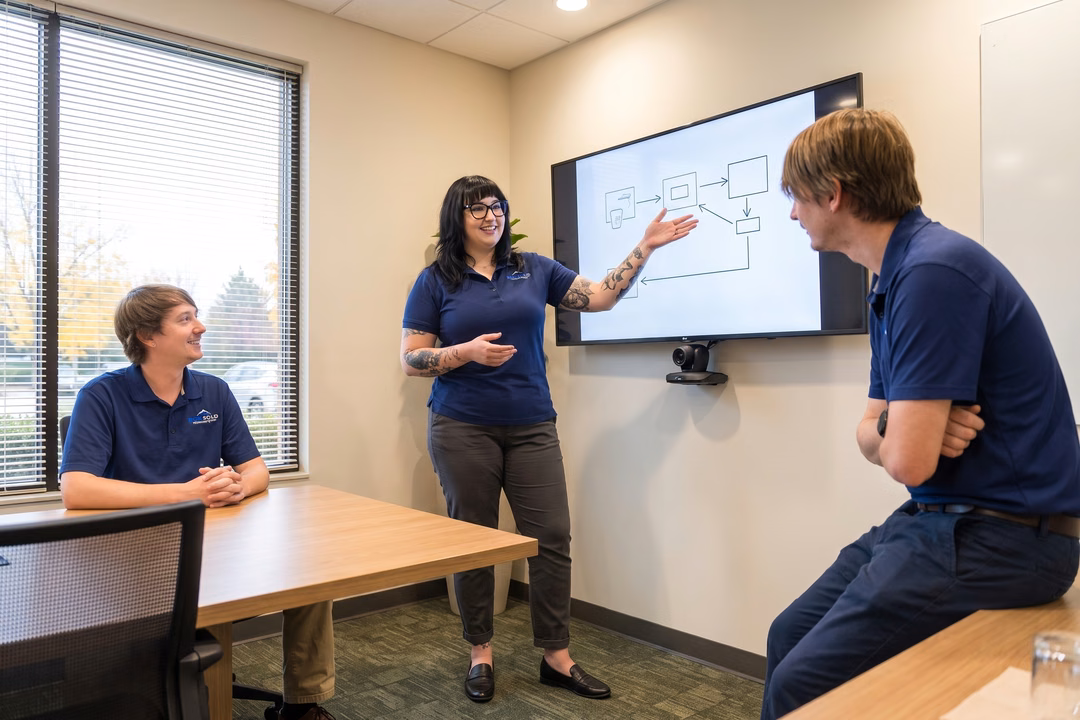 IT compliance specialist presenting a workflow diagram to colleagues during a managed services team review meeting