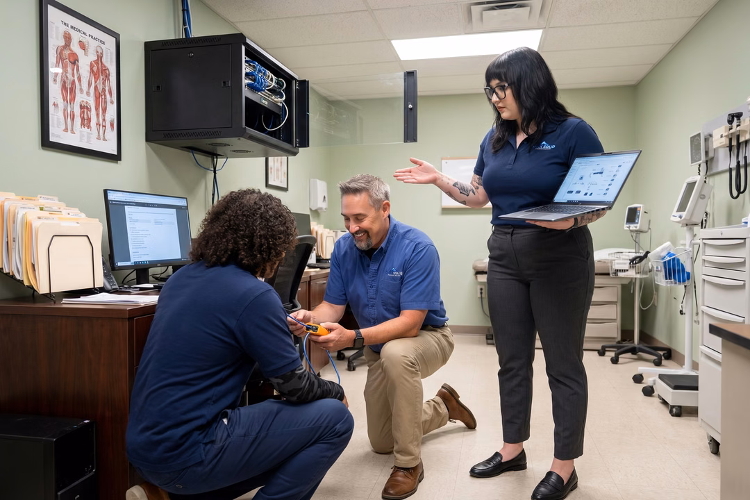 Rock Solid IT technicians performing network troubleshooting and status monitoring in a medical office setting