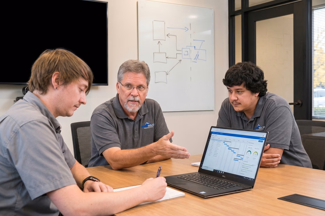 Rock Solid Technology Solutions IT team reviewing security camera installation plans on a Dell laptop in a conference room