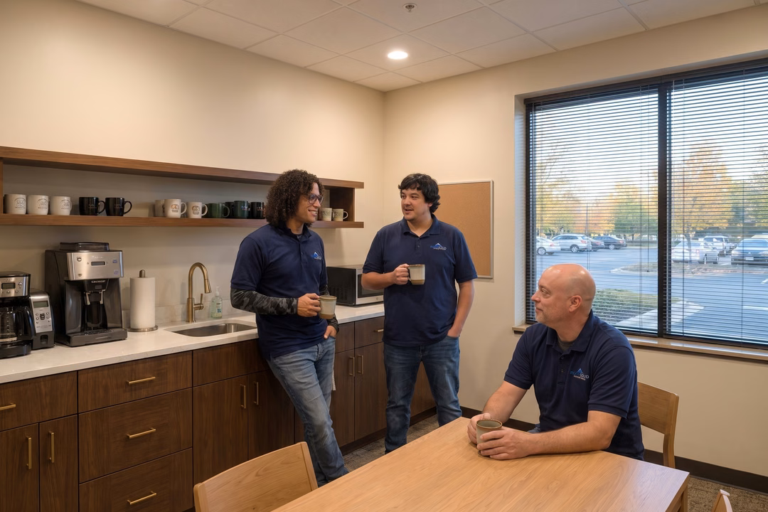 Rock Solid Technology team members discussing nonprofit IT support solutions in a modern office break room