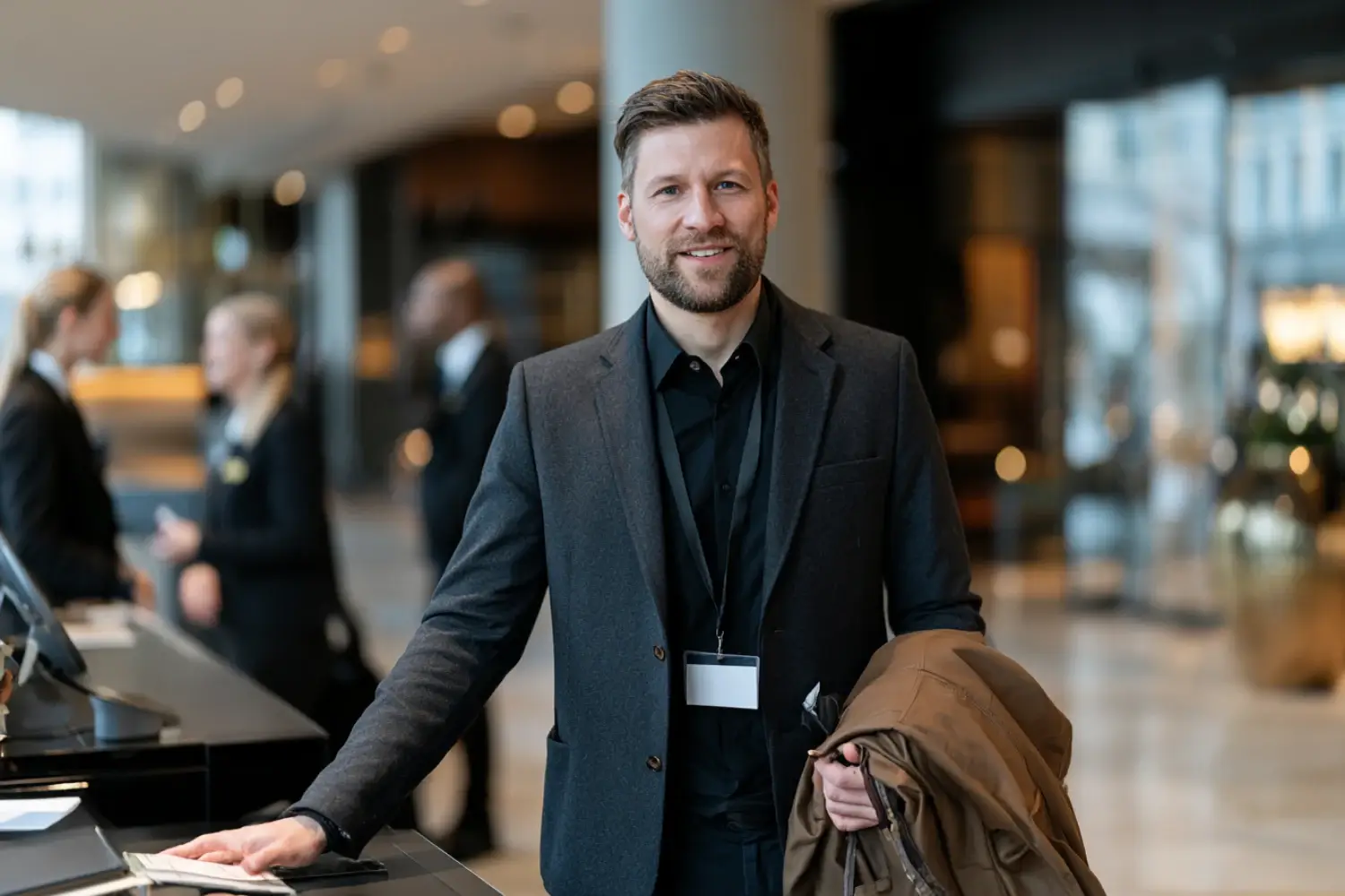 Hospitality staff using tablet to assist dining guests in upscale restaurant, demonstrating IT-managed service solutions