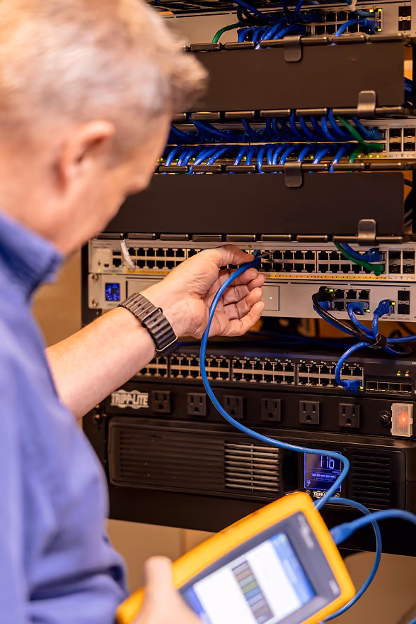 Rock Solid Technology technicians performing network diagnostics and IT system inspection inside a manufacturing facility