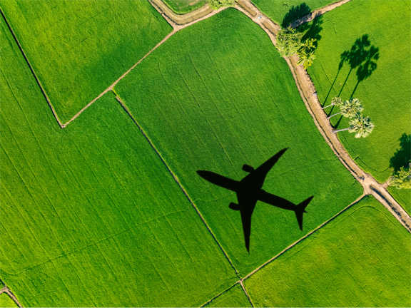Plane shadow flying over green land