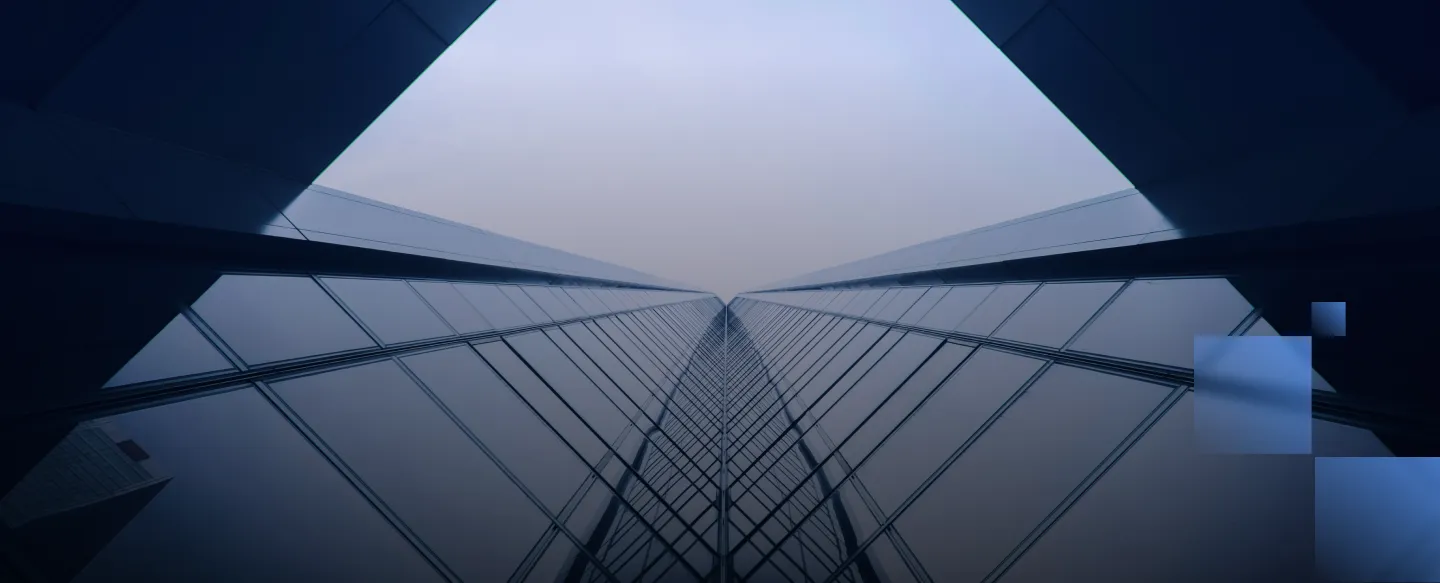 Looking up at a glass skyscraper reflecting the sky and converging at a vanishing point.