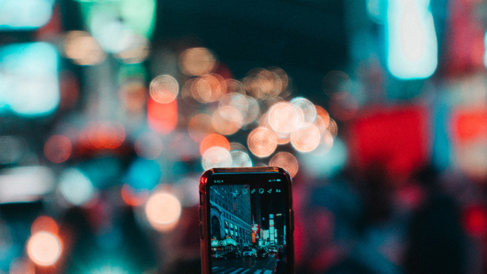 Créateur photographiant la ville de nuit avec son téléphone