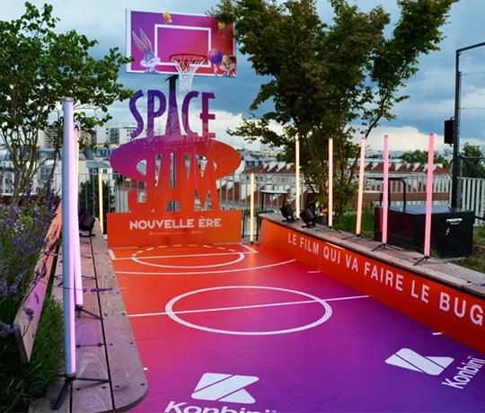 A vibrant pop-up basketball court set up on a rooftop, themed after the movie *Space Jam: A New Legacy*.