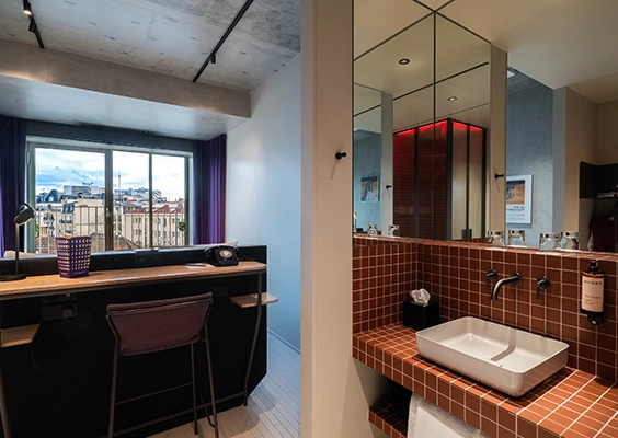 Aperçu séparé d'un espace travail moderne avec bureau haut et d'un coin lavabo au carrelage terre cuite.