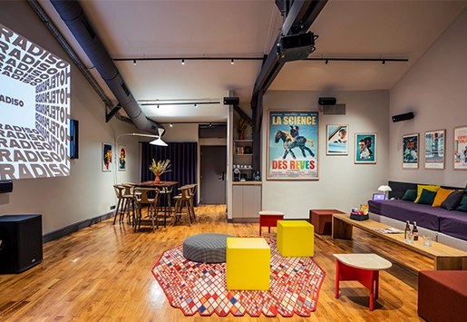 Spacious, modern loft featuring hardwood floors, movie posters, a projection screen, and colorful seating.