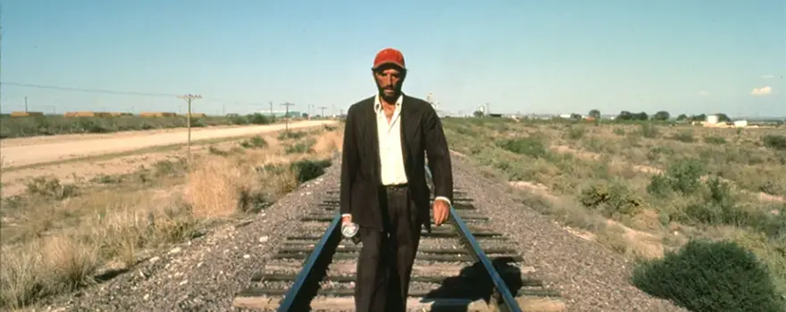 Homme en costume marchant sur des rails de train