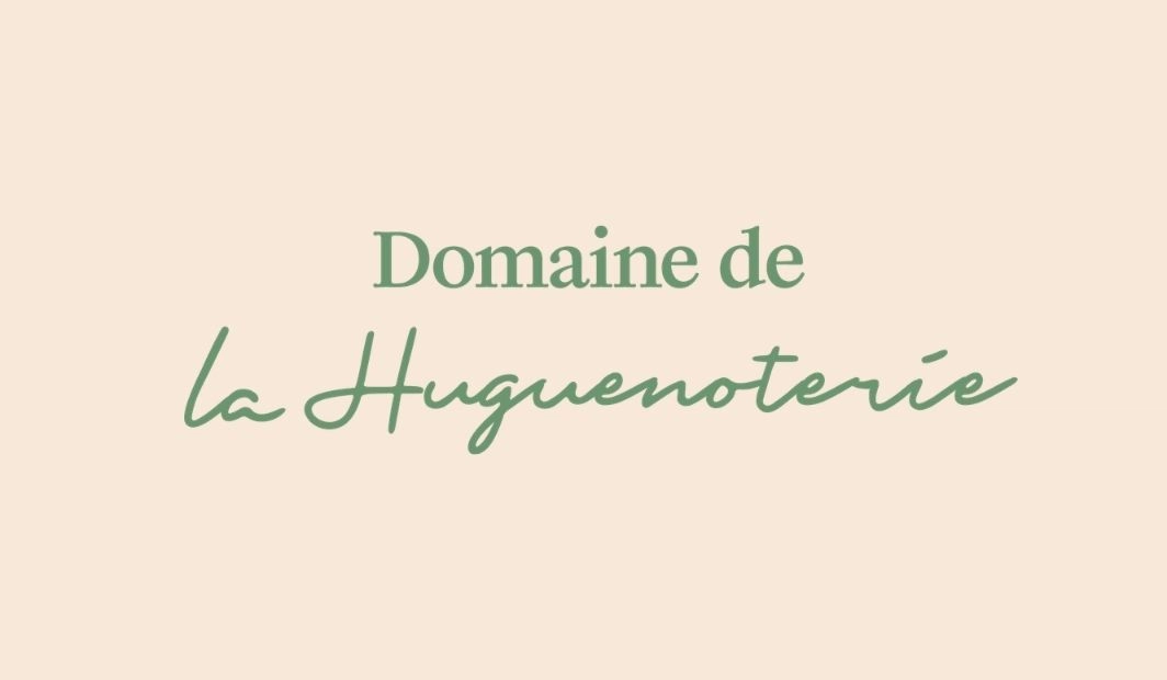 Logo Domaine de la Huguenoterie avec typographie verte élégante sur fond beige rosé