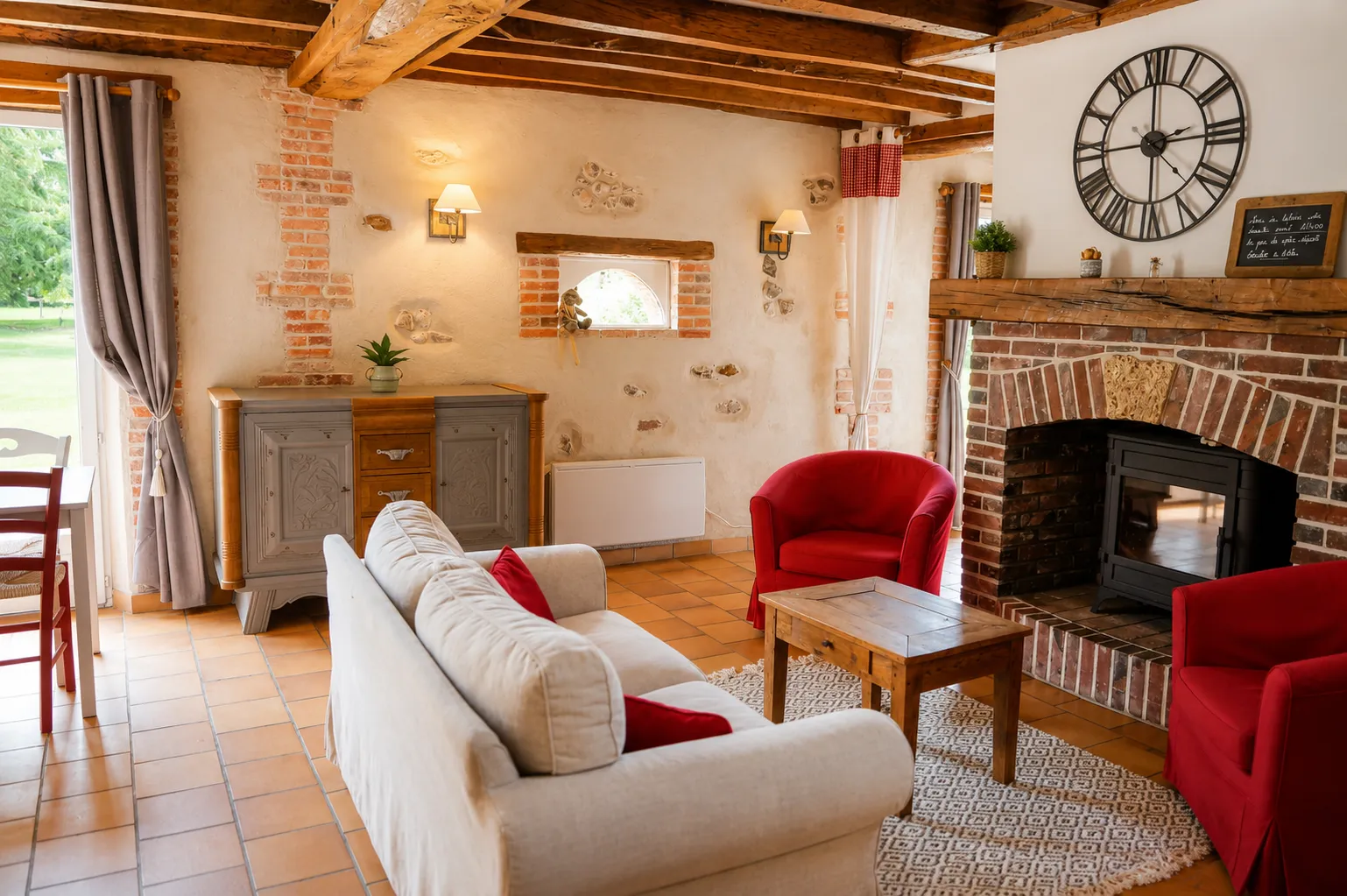Salon de la maison, avec son canapé et sa cheminée au Domaine de la Huguenoterie.