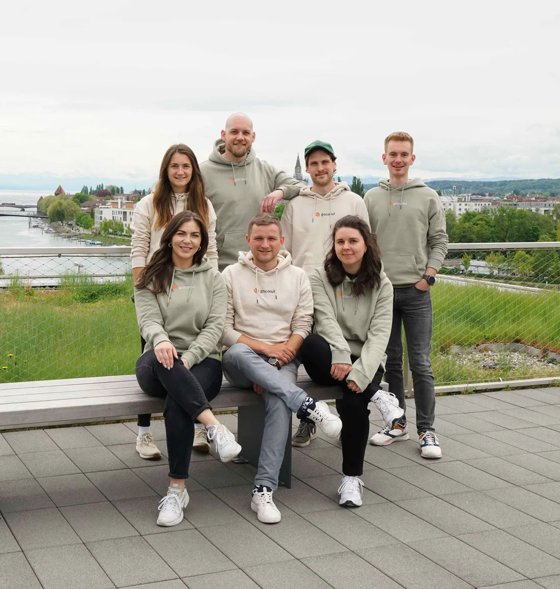 Das goconut team steht auf einer Dachterrasse mit Blick auf Konstanz.
