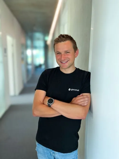 Teammitglied – Person steht angelehnt an einer Wand