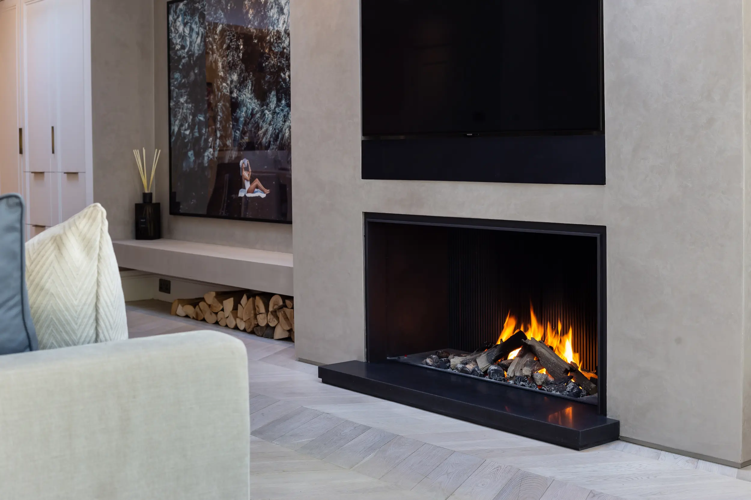 Side view of minimalist gas fireplace with matt black steel interior and ribbed back panel designed in collaboration