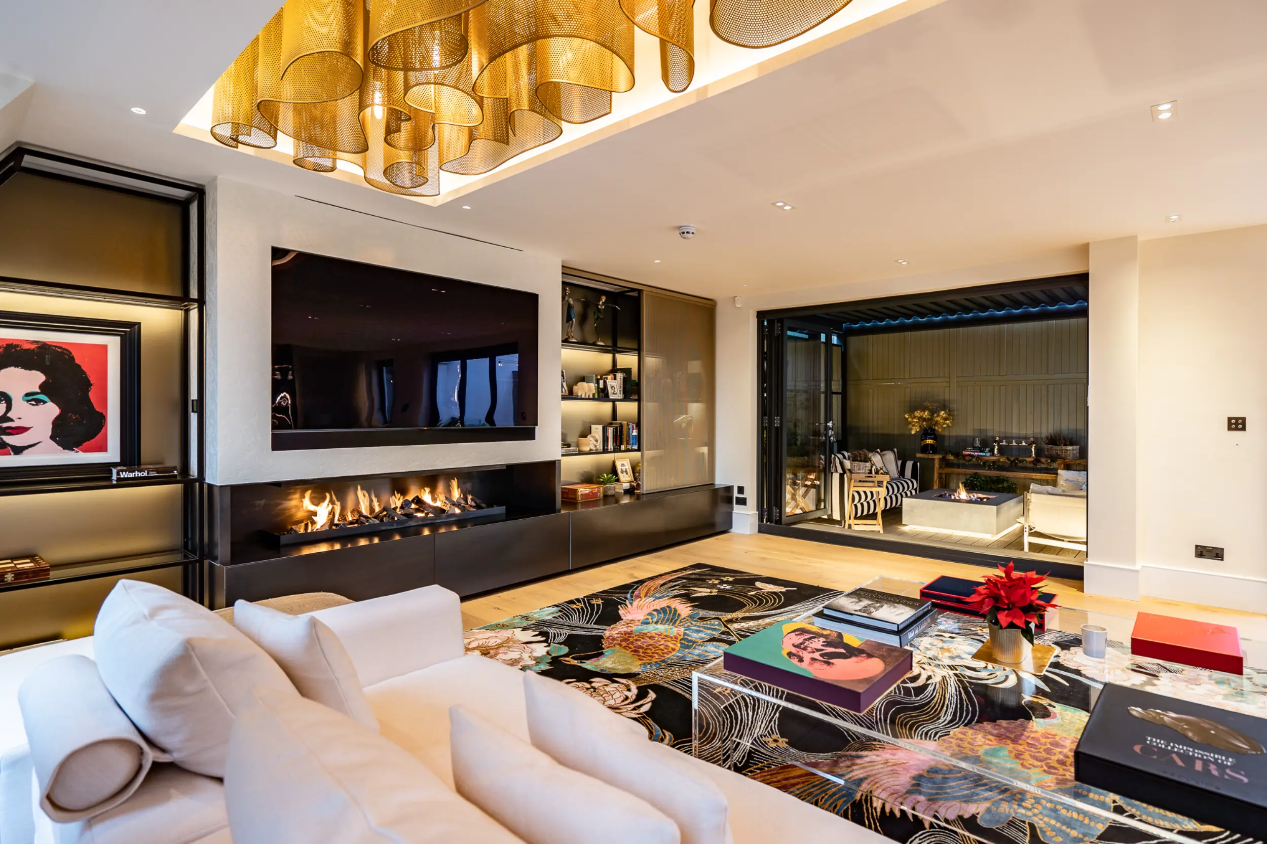 Side view of bespoke open-front gas fireplace with blue steel cladding integrated within contemporary penthouse media wall