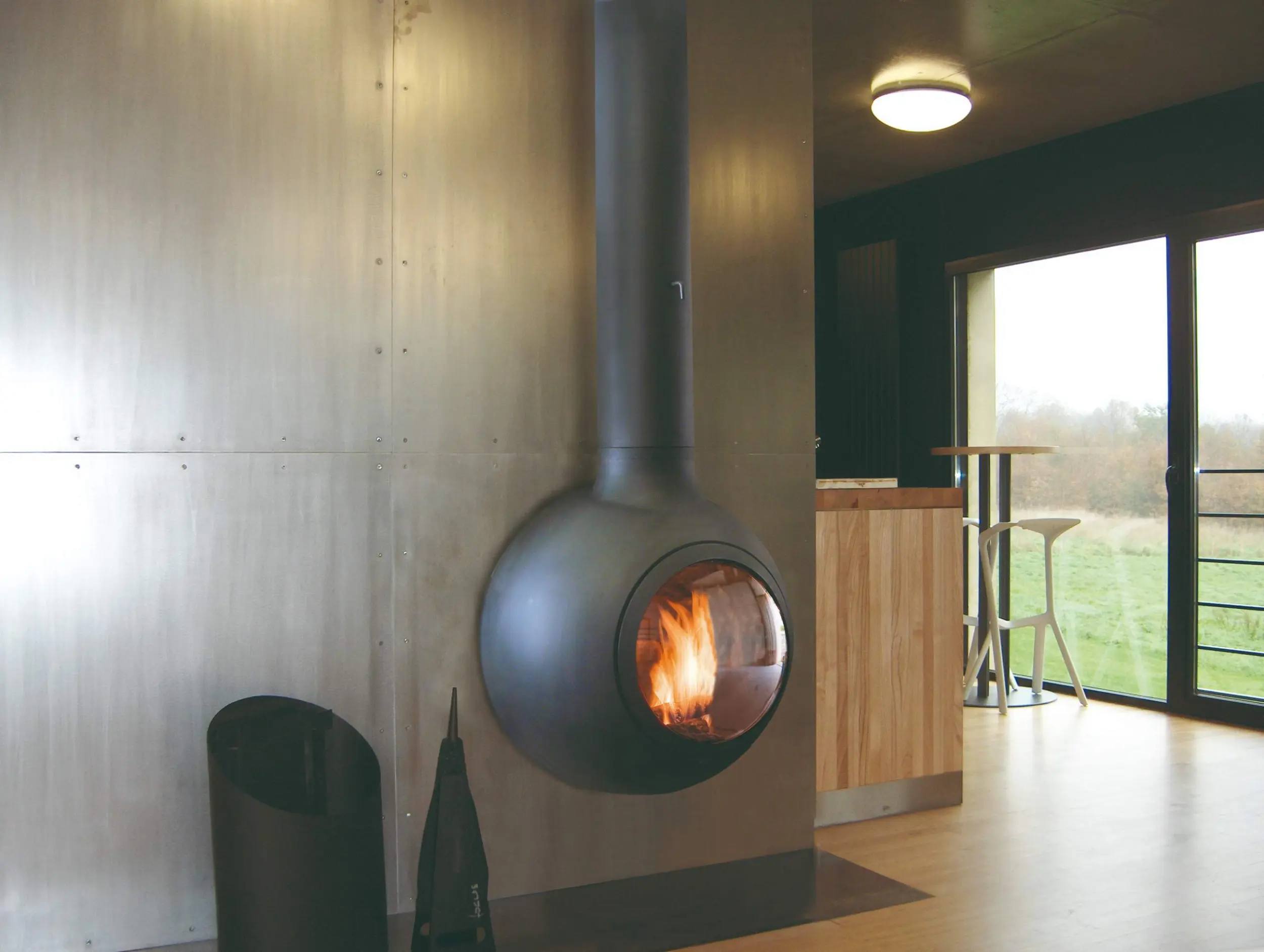 Emifocus wall-mounted spherical wood-burning fireplace by Focus Creation, with circular glass porthole and rounded form